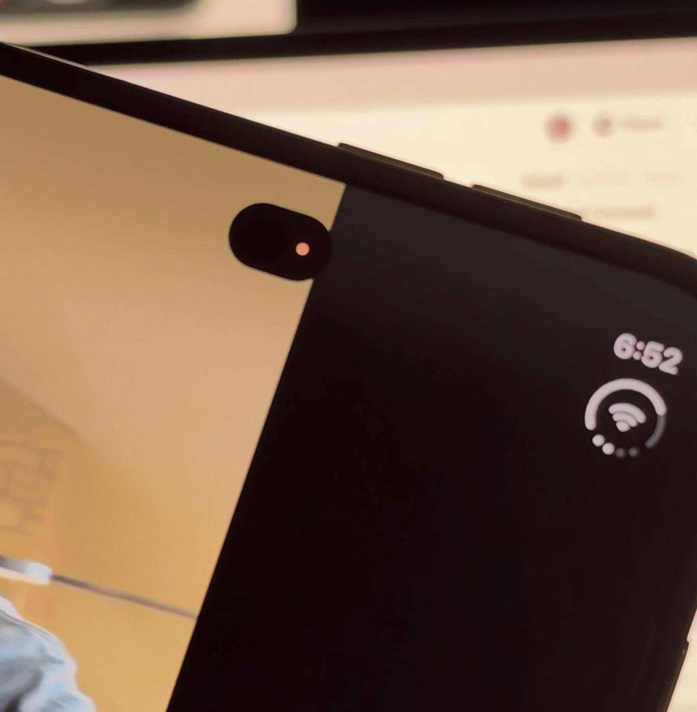 Close-up of the iPhone Duo’s under-display camera and green camera indicator.